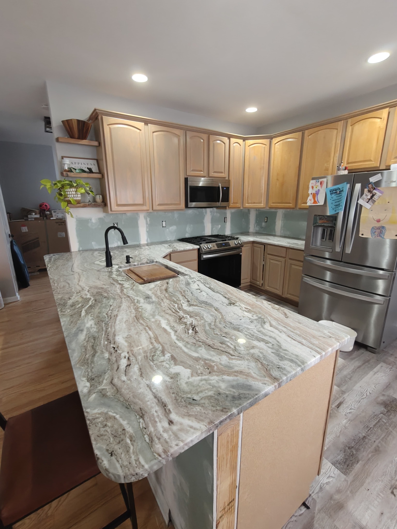 Completed kitchen with flowing natural stone countertop and large island