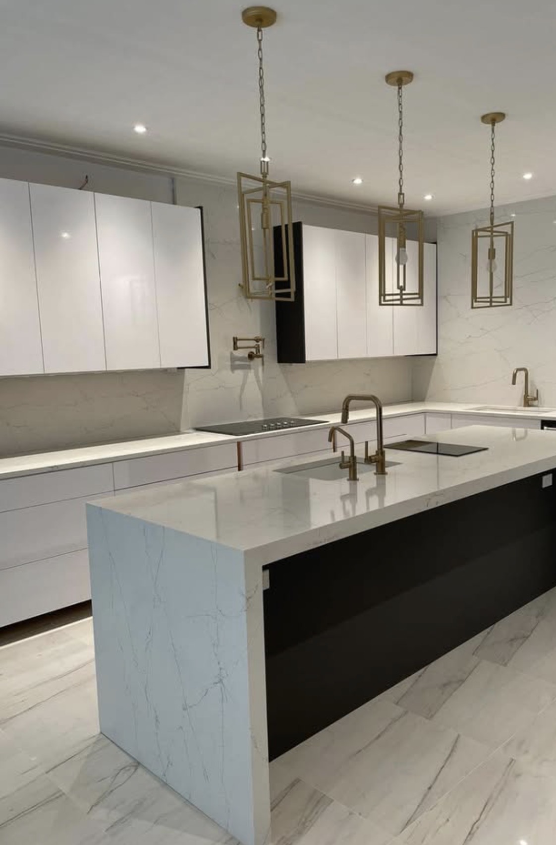 Finished bright contemporary kitchen with white waterfall stone island